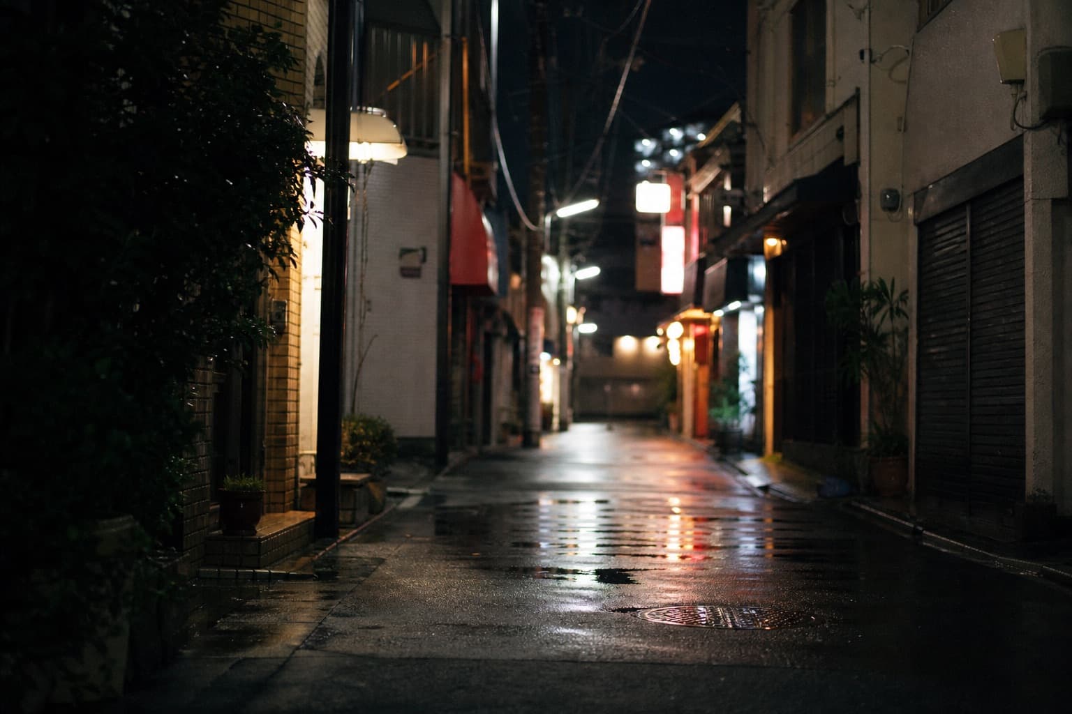 雨上がりの夜の繁華街の路地とネオンのボケ